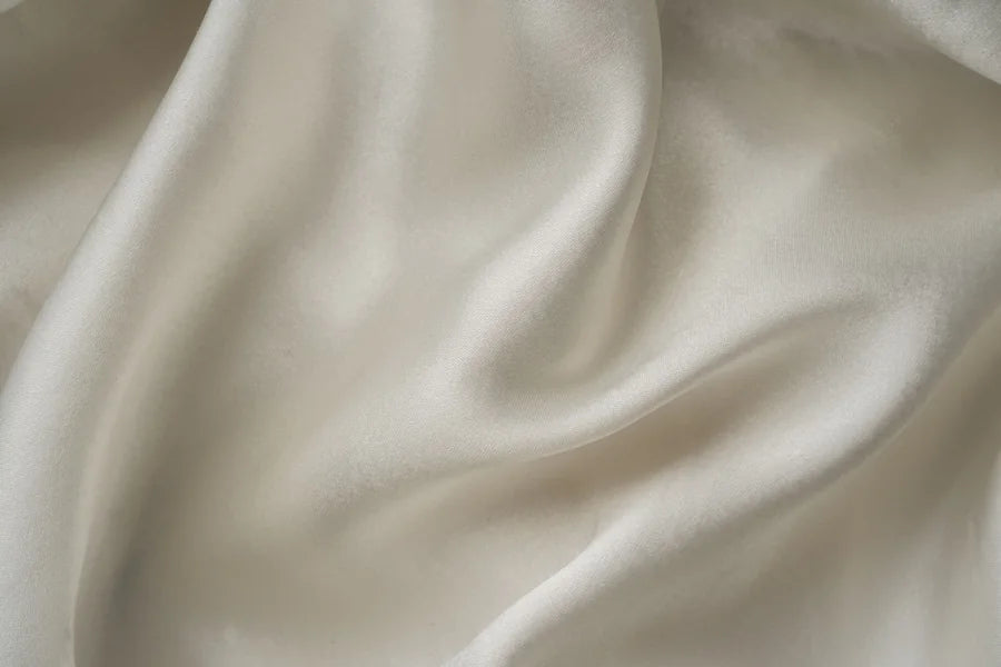 Soft folds of warm ivory satin